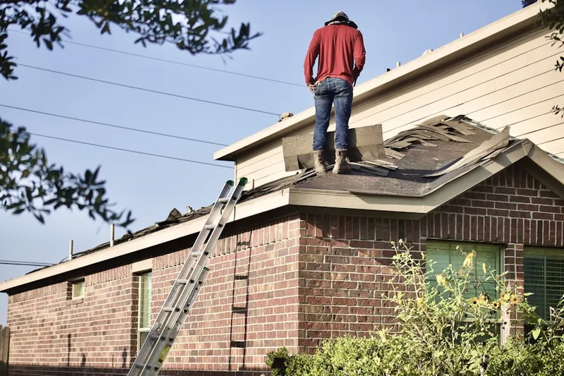 Professional roofer working on a residential roof in Oberlochen